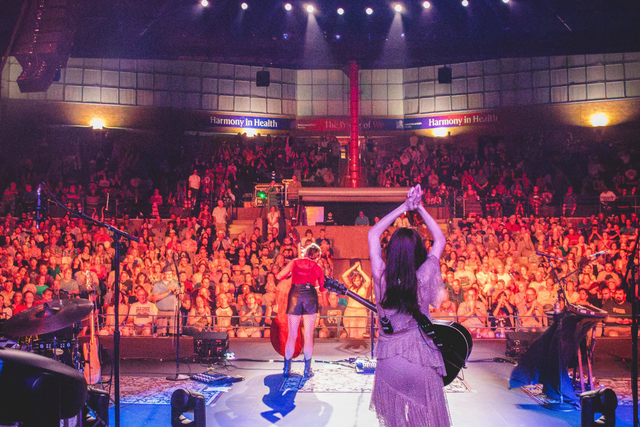 Singers perform onstage at the Arvada Center, looking out over the crowd