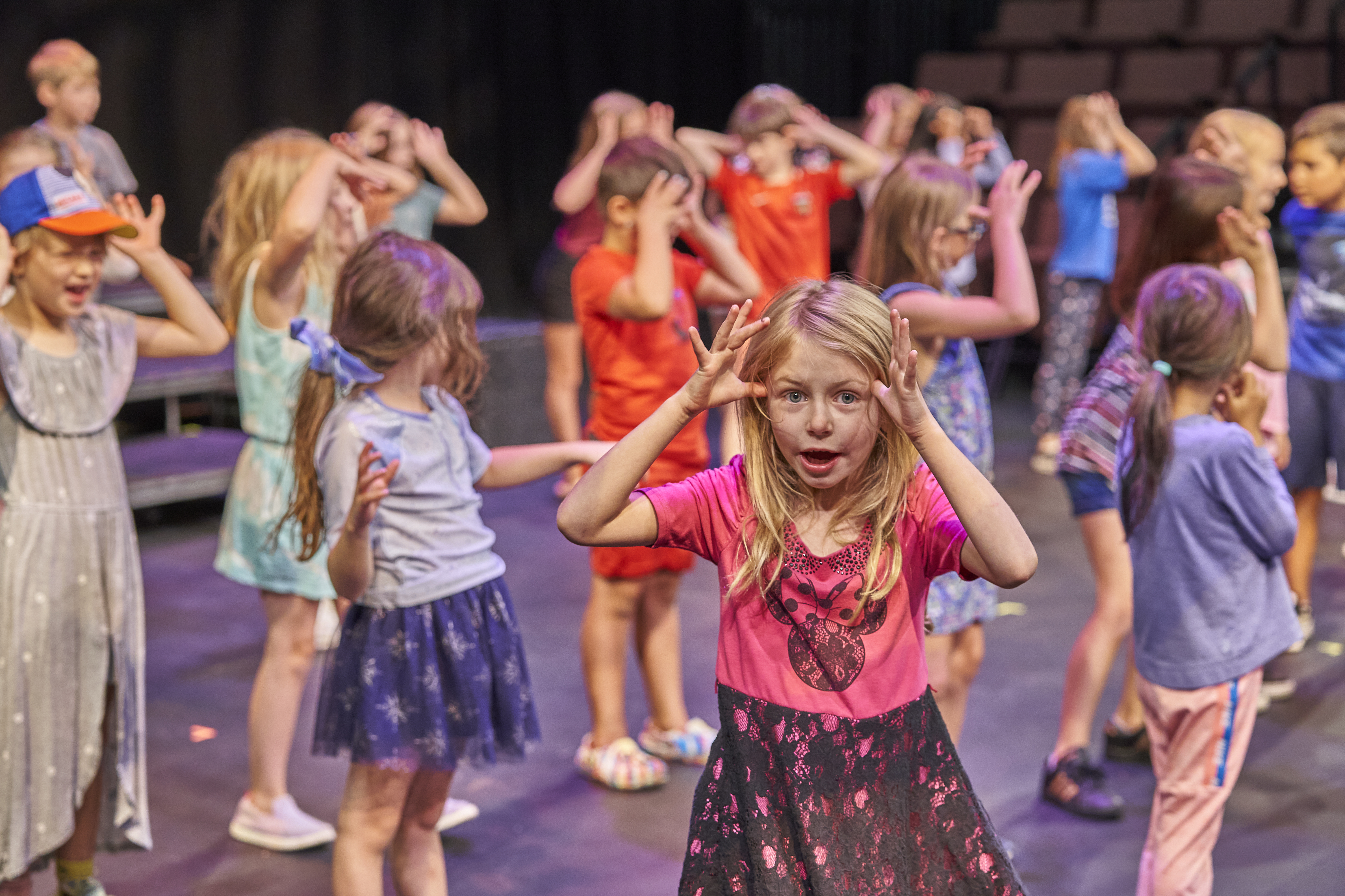 Kids in a summer camp class make silly faces at the camera